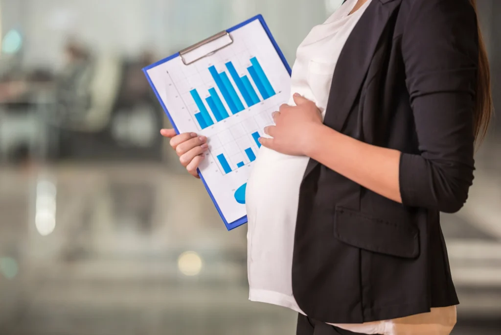 A pregnant woman with a clipboard with graphs.