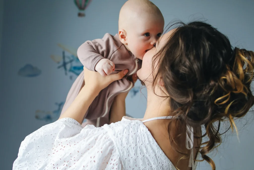 A mom holding up her baby.