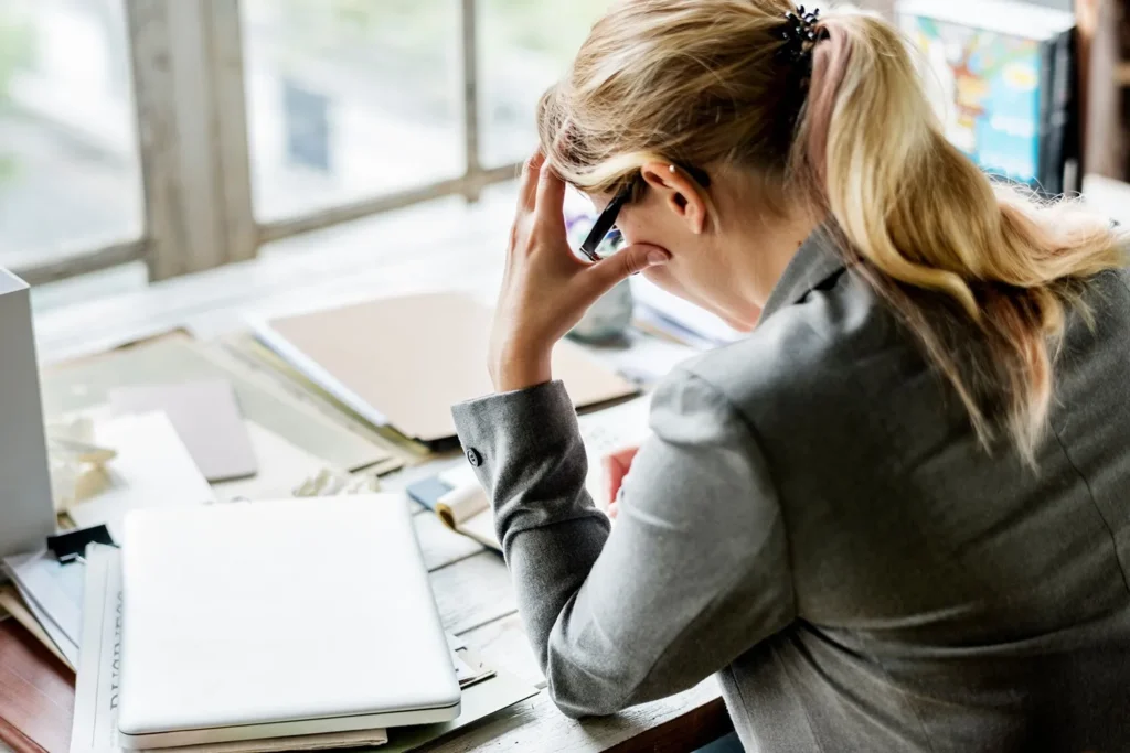 Stressed employee sitting at desk.