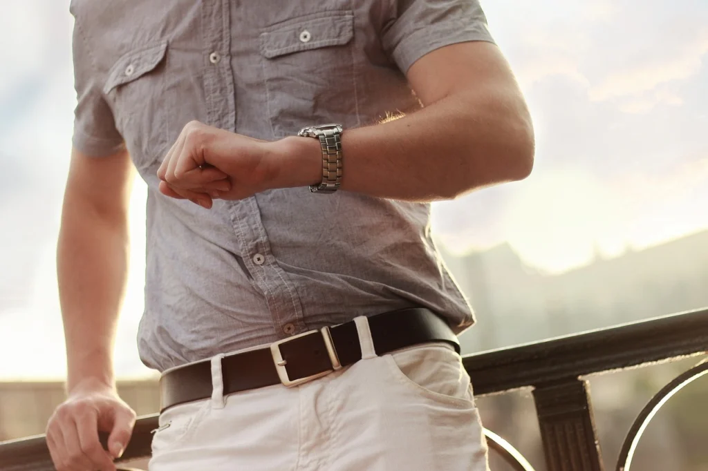 A man dressed nicely looking at his watch