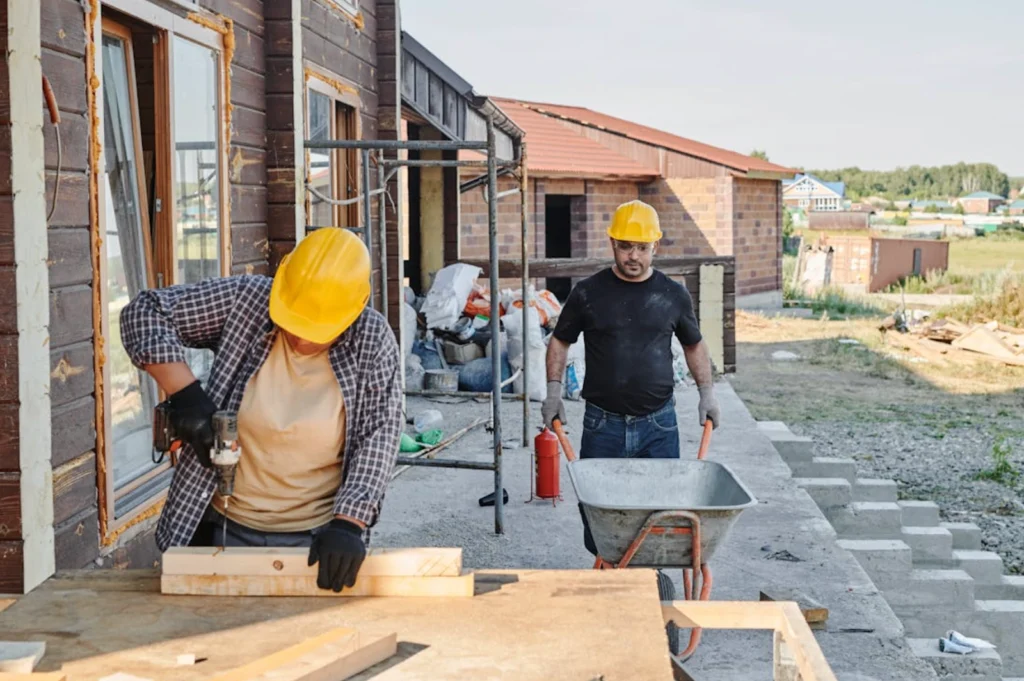 Two construction workers working outside at a site
