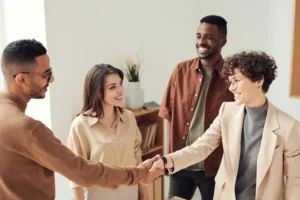 A group of happy professionals, two of them shaking hands